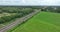 Dutch train passing commuting traveling in forrest grassland nature landscape. Sustainable travel technology by rail