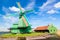 Dutch typical landscape. Traditional old dutch windmill against blue cloudy sky in the Zaanse Schans village, Netherlands. Famous