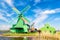 Dutch typical landscape. Traditional old dutch windmills with house and swan against blue sky in the Zaanse Schans village, Nether