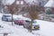 Dutch village street with parked cars covered in snow, a cold winter day with snowy weather in the Netherlands