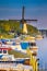 Dutch Windmill In Front of The Canal With Moored Motorboats at Marina Located in Traditional Village in The Netherlands. Shot at