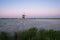 Dutch windmill near a lake with pink sky