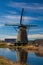 Dutch windmill reflecting in the canal water in Kinderdijk Holland