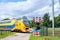 Dutch yellow high speed intercity train passing a closed railway crossing with closed barriers and blinking red lights