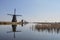 Duth windmills with reflection in the water with blue sky and re