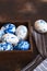 Dyed Easter eggs. Ð¡lassic blue Easter eggs on the grey background. Blue speckled easter eggs with paint and brushes. Decorating