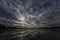 Dynamic clouds in the night over the lake lit by full moon