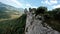 Dynamic Drone shot along Rocky mountain cliff turns to a dive