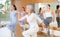 Dynamic elderly woman practicing aerobic dance in training hall