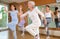Dynamic elderly woman practicing aerobic dance in training hall