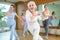 Dynamic elderly woman practicing aerobic dance in training hall