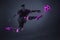Dynamic image of concentrated young man, soccer player in motion, kicking ball in a jump. Purple black color combination