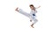 Dynamic portrait of young girl, teen, taekwondo athlete jumping isolated over white background. Concept of sport