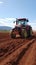 Dynamic Red Tractor Ploughing Rich Brown Soil Field