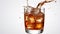 dynamic splash of a cola being poured into a glass filled with ice isolated on white