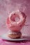 Dynamic Splash of Pink Glaze Covering Delicious Donut on a Plate with a Vivid Magenta Background