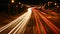 Dynamic urban nightscape blurred car lights in high speed traffic on illuminated city highway