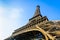 Dynamic view from below of the Eiffel Tower against blue sky