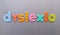 Dyslexia word spelled out in bright colorful patterened letters on brushed metal background