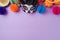 DÃ­a de los Muertos day of the dead holiday concept. Sugar skull mask and Mexican party decorations on purple background. Top view