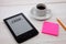 E-book reader and coffee cup on wooden table