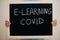 E-learning covid. Coronavirus concept. Boy hold inscription on the board