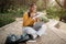 E-learning. Happy brazilian student lady preparing lesson, using laptop and taking notes, sitting outside in park