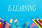 E-learning inscription on the background of a blackboard and school supplies . The concept of education, study, training, e-
