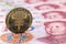 E-RMB gold coin, over 100 yuan banknotes, conceptual image of the digital version of the yuan. Chinese decentralized currency