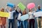 We each have something to say. Portrait of a group of people holding speech bubbles against a wall outside.