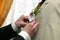 Each helps to put the flower on the suit for the groom