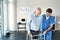 Each step will get easier. a male nurse assisting a senior patient with a walker.