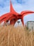 Eagle an abstract sculpture by Alexander Calder located in Seattle on 2000 with Space Needle rising above golden grass