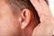 Ear of a man close up with hearing aid.