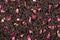 Earl grey black dry tea leaves with rose petals background