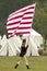 An early American flag is flown by solider on his way to Surrender Field at the 225th Anniversary of the Victory at Yorktown, a re