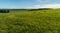 Early autumn rural landscape with meadows, forests, small hills and blue sky with clouds