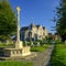 Early evening autumn light on St Thomas the Martyr church and village cross, Winchelsea, East Sussex, UK