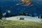 Early frosty morning in the mountains. A wooden shed in the pasture, fields covered with hoarfrost and mountains overgrown