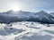 An early frosty morning and the rising sun over the snowy alpine peaks of the famous Swiss winter resort of Arosa