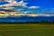 In the early morning, the distant rolling mountains, the golden cloudscape and the nearby rice fields form a picturesque scenery