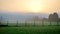 Early morning fog and sunrise on football field with soccer goal