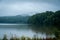 Early morning mist over the mountains around a lake with a calm reflective water surface