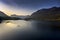 Early morning paddle boarders sail across Crummock Water a lake in the Lake District part of the UNESCO World Heritgae Centre in