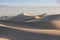 Early Morning Sunlight Over Sand Dunes And Mountains At Mesquite flat dunes, Death Valley National Park, California USA