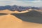 Early Morning Sunlight Over Sand Dunes And Mountains At Mesquite flat dunes, Death Valley National Park, California USA