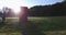 An early morning sunrise and a fire hydrant in the foreground, shot along a road with hilly residential backgrounds.