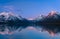 Early morning sunrise illuminating serene waters of Lake McDonald, Glacier National Park, Montana