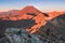 Early morning sunrise, landscape scenery of blue lake, wild mountains and huge volcano, autumn colours and golden sun rays.