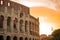 Early morning view of the colosseum in Rome, red and blue skies with sun just about to rise above the great famous amphitheatre.